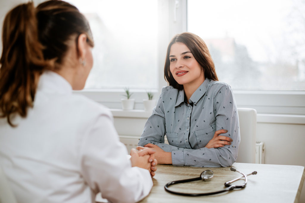 Young woman consulting with a doctor in her office about her gynecological services Complete Healthcare Primary Care and Gynecology