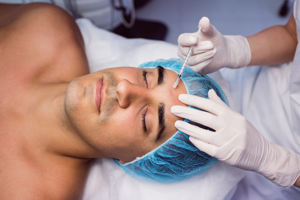 Man getting botox injections on forehead from nurse in her office Complete Healthcare Primary Care and Gynecology