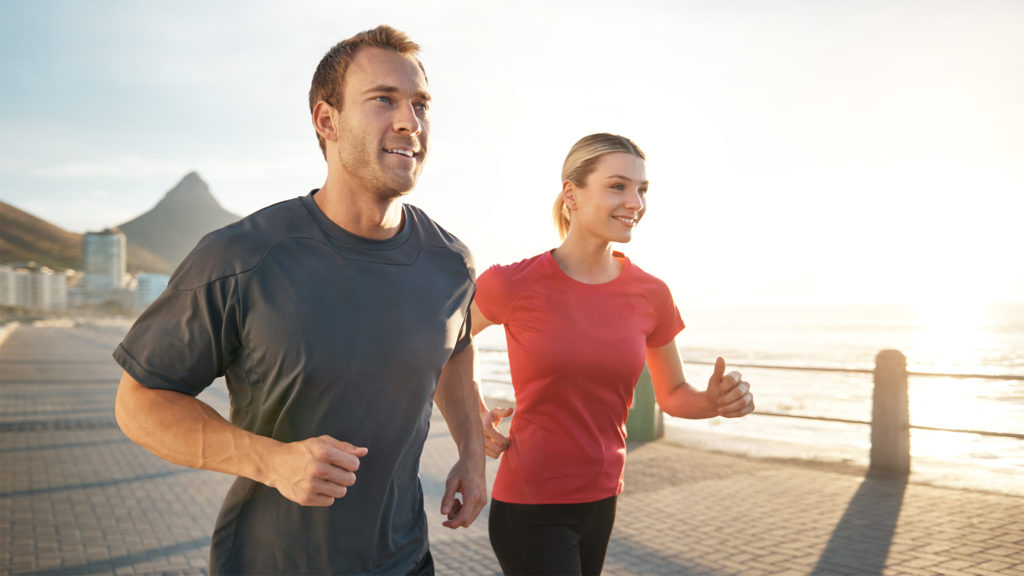 Couple joggin on sideway by the ocean to lower cholesterol Complete Healthcare Primary Care and Gynecology