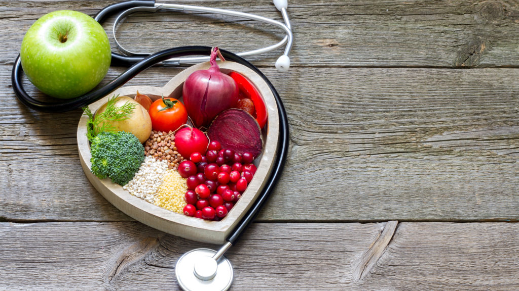 healthy food and stethoscope on wood background Complete Healthcare Primary Care and Gynecology
