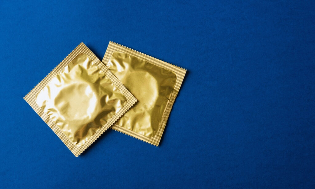 Yellow condom wrappers against a blue background
